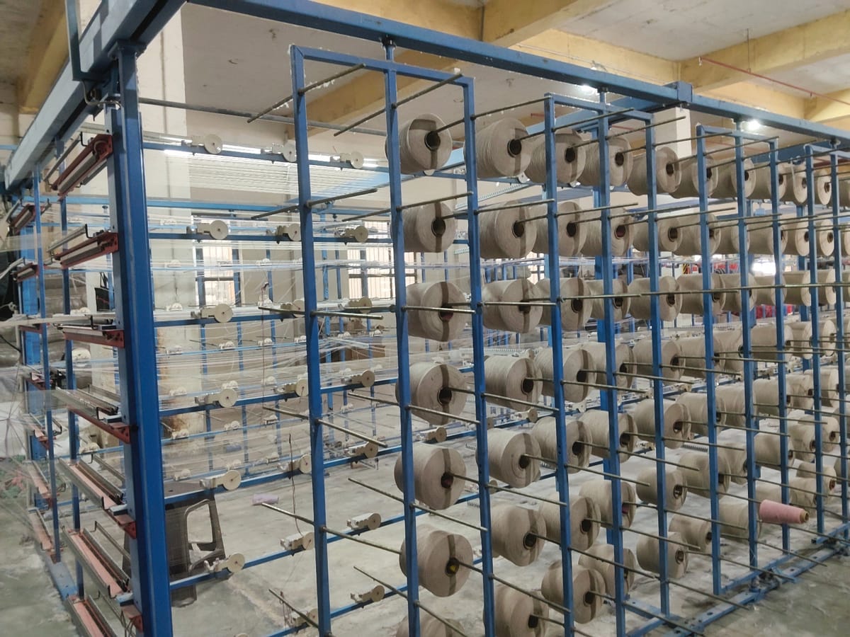 Yarn cones on racks, textile spinning unit