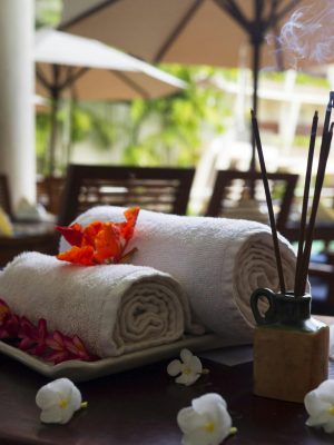 Relaxing spa scene with towels, incense, and flowers, perfect for wellness themes.