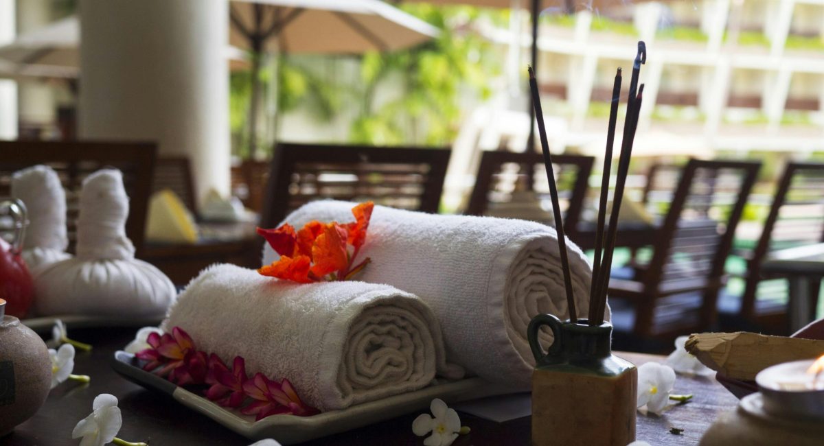 Relaxing spa scene with towels, incense, and flowers, perfect for wellness themes.