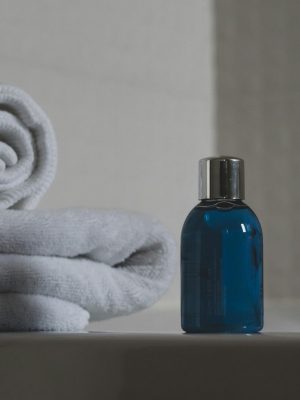 Luxurious white towels and blue bottle create a tranquil spa atmosphere.